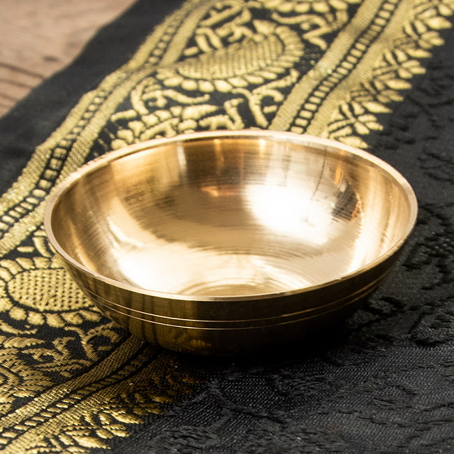 金色の小皿[直径:5cm]の写真1枚目です。ブラスが美しいインドの器です。線の本数など、細かいデザインが異なる場合がございます。ディヤ,ディワリ,オイルランプ